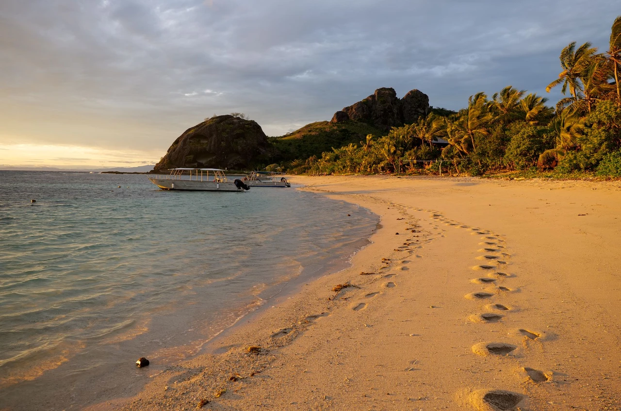 Golden sunset over a beach with boats on the Yasawa Islands, Fiji