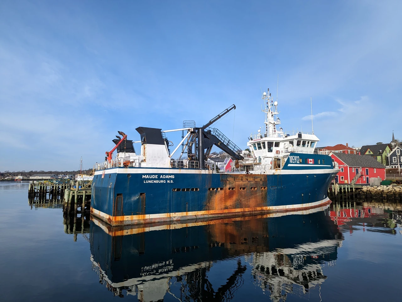 Colourful historic waterfront buildings and a fishing boat in Lunenburg harbour, Nova Scotia